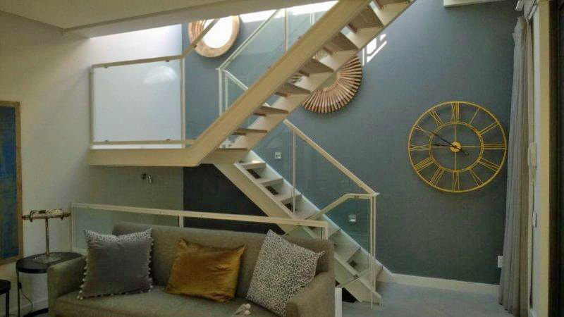 Straight staircase with glass balustrades.